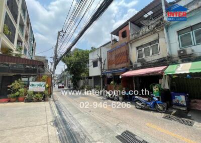 Street view of residential and commercial buildings with visible real estate banner