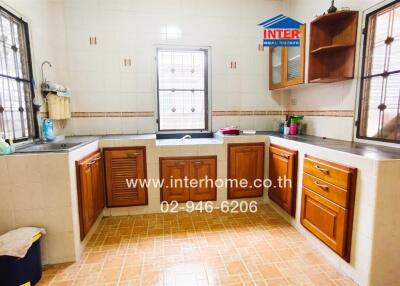 Spacious kitchen with wooden cabinets and tiled flooring