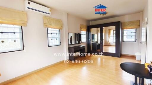Spacious and well-lit living room with air conditioning and hardwood floors
