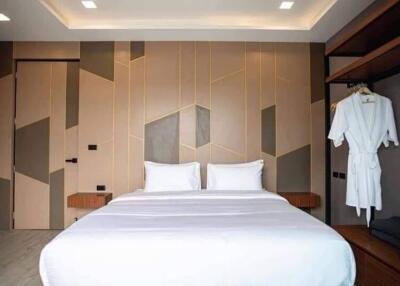 Modern bedroom with geometric wall design and elegant furnishings