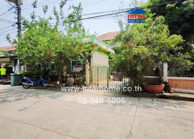 Exterior view of a residential house with greenery and a motorcycle parked outside