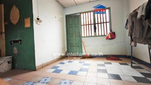 Simple interior room with tiled floor and green door