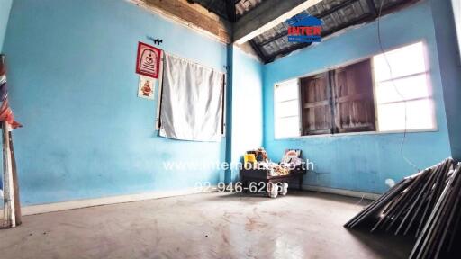 Spacious unfinished room with blue walls and a large window