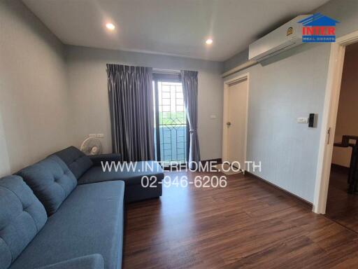 Cozy and well-lit living room with blue sofa and balcony access