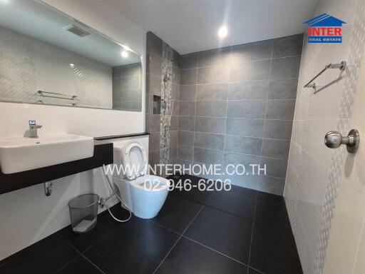 Modern bathroom with washing machine and stylish tiles
