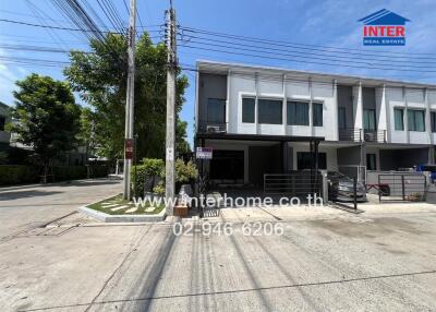 Exterior view of a modern townhouse with advertising sign