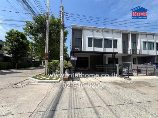 Exterior view of a modern townhouse with advertising sign