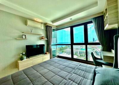 Well-furnished bedroom with large windows overlooking the city