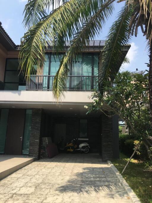 Modern two-story house with balcony and palm trees