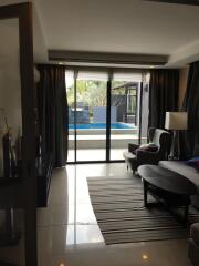 Spacious living room with pool view through glass doors