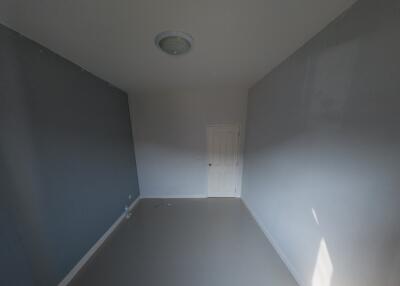 Empty hallway with a white door at the end, lit by natural light