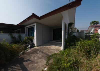 Exterior view of a single-story house with a spacious front yard