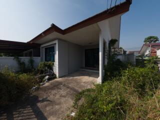 Exterior view of a single-story house with a spacious front yard