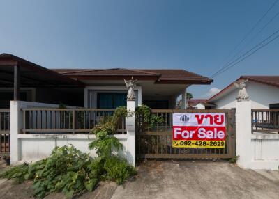 Front view of a house for sale with a visible sale sign
