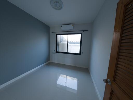 Spacious and Well-lit Bedroom with Reflective Flooring and Large Window