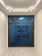 Elegant entrance with wooden framed glass doors and tiled flooring
