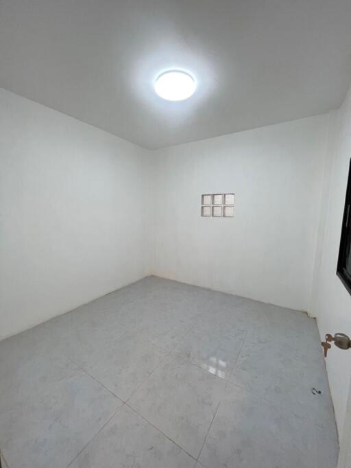 Small empty bedroom with white walls and tiled floor