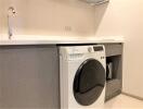 Modern laundry room with washing machine and built-in cabinets