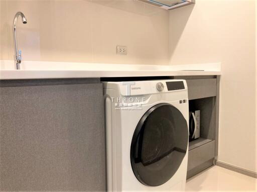 Modern laundry room with washing machine and built-in cabinets