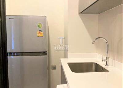 Modern compact kitchen with stainless steel refrigerator and sink