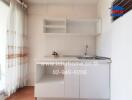 Compact white kitchen with built-in cabinets and sink