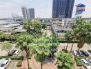 Scenic outdoor view of the property with lush palms, parking area, and urban backdrop