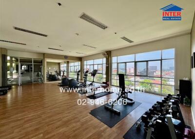 Spacious gym area with modern equipment and large windows in a residential building