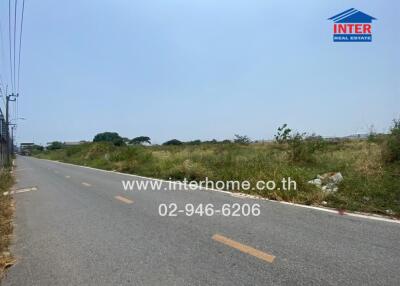 Empty land available for development next to a paved road