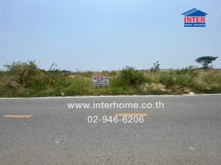 Empty land for sale with clear sky and roadside view