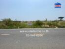 Empty land for sale with clear sky and roadside view