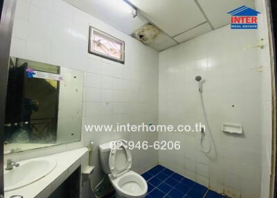Small white-tiled bathroom with blue floor