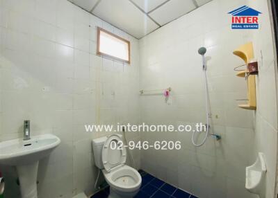 Compact tiled bathroom with shower and small window