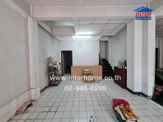 Spacious living room with white tiles and staircase