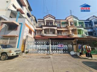 Multi-story residential building facade with parking space