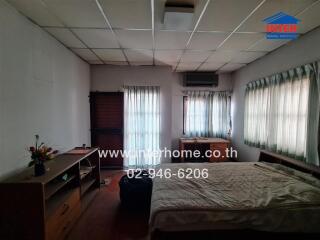 Spacious Bedroom with Large Windows and a Bed in a Real Estate Property