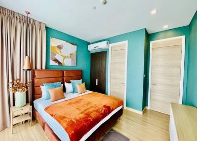 Bright and cozy bedroom with teal walls and wooden furnishings