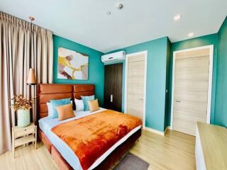 Bright and cozy bedroom with teal walls and wooden furnishings