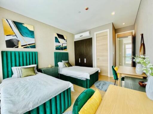 Modern twin bedroom with vibrant decor and ample natural light