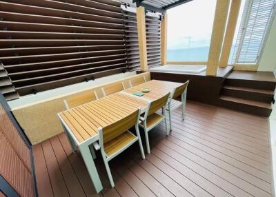 Spacious balcony with wooden furniture and sea view