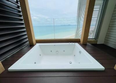 Luxurious beachfront bathroom with a large white bathtub and ocean view