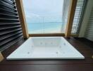 Luxurious beachfront bathroom with a large white bathtub and ocean view