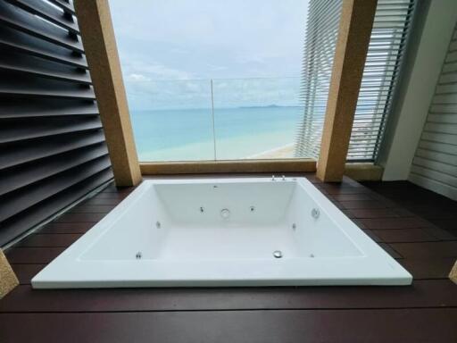 Luxurious beachfront bathroom with a large white bathtub and ocean view