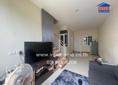 Spacious and modern living room with staircase and access to other rooms