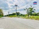 Spacious outdoor area near a road with a real estate sign