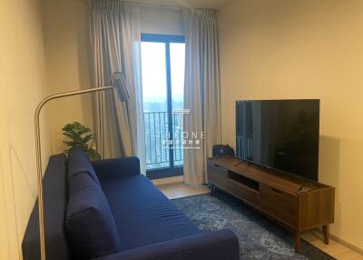 Modern living room with a blue sofa, television and balcony