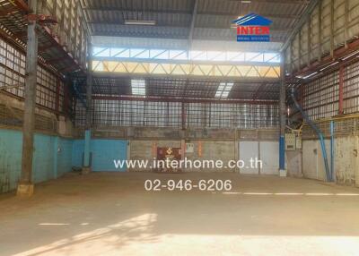 Spacious warehouse interior with high ceiling and ample natural light