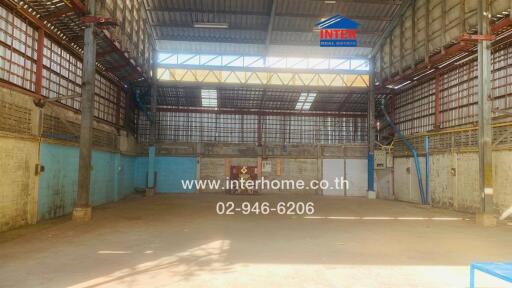 Spacious warehouse interior with high ceiling and ample natural light