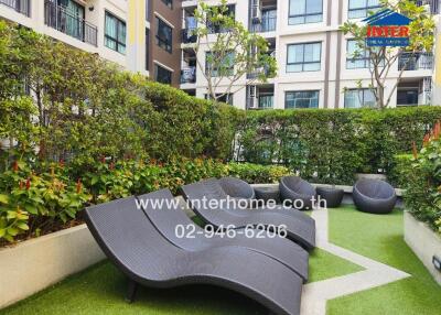 Well-maintained communal garden in a residential apartment complex with seating arrangement