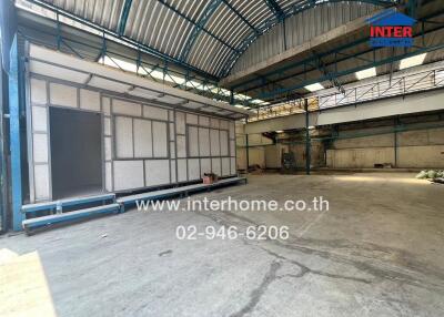 Spacious industrial warehouse interior with large doors and high ceiling