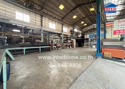 Spacious industrial warehouse interior with machinery and construction materials